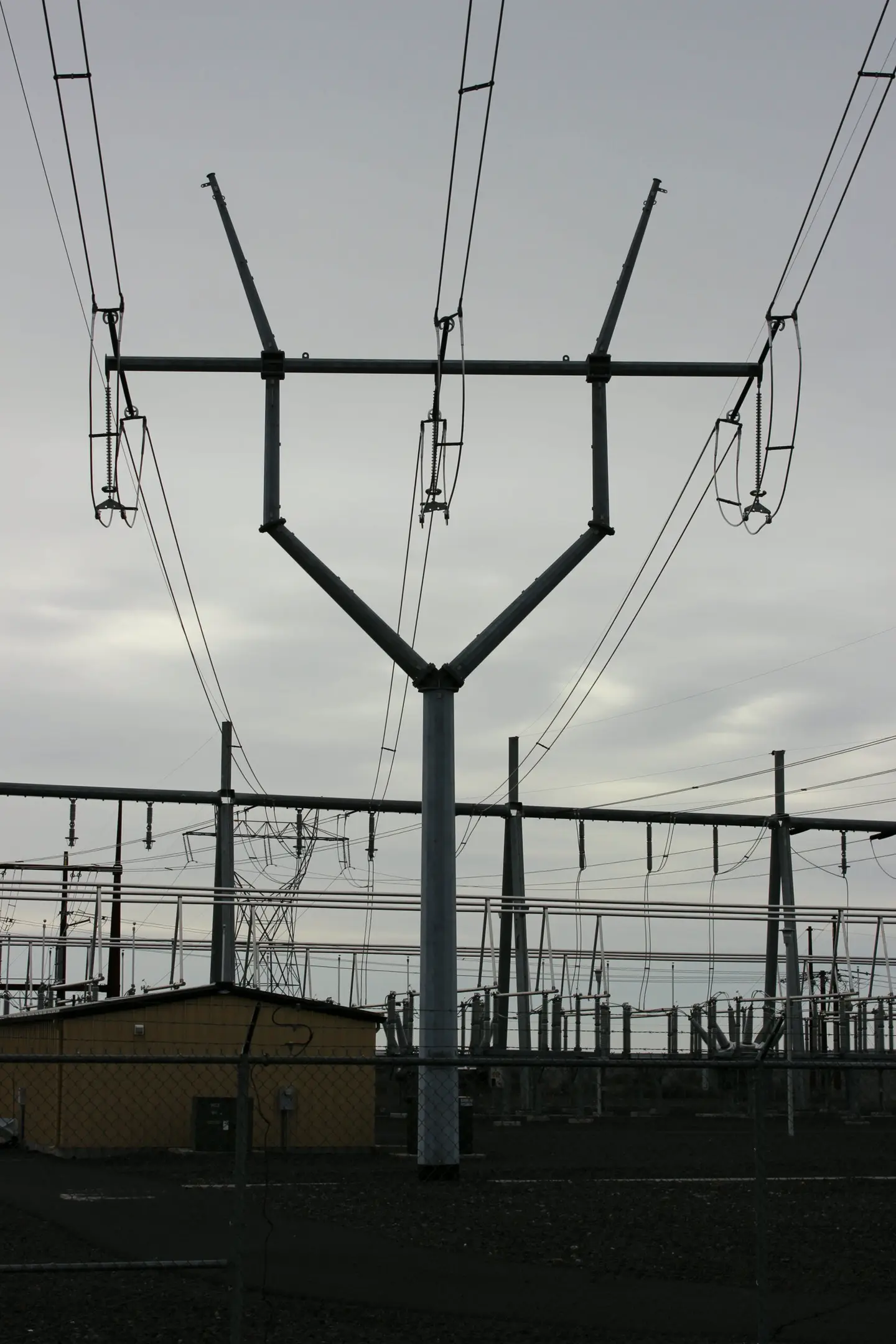 Y-shaped steel transmission structure at a substation under an overcast sky