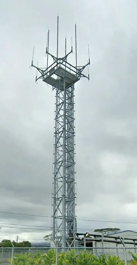 Lattice steel tower with an antenna platform under an overcast sky
